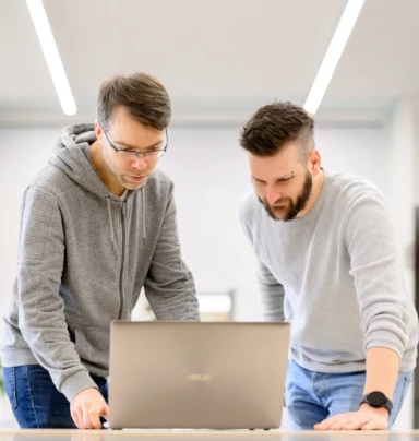 Alex zeigt Hannes im Pair-Programming seinen aktuellen Stand.